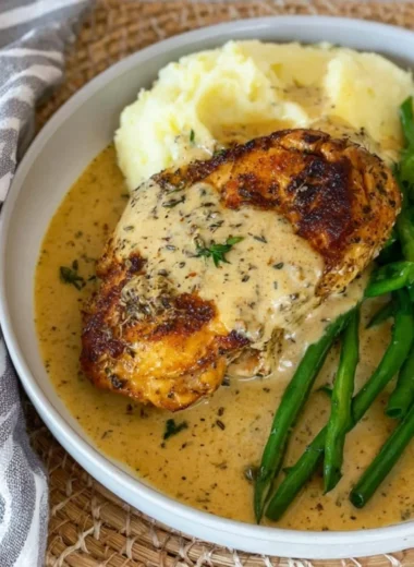Creamy chicken schnitzel topped with parmesan sauce on a plate.