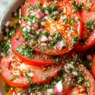 Delicious marinated tomatoes served in a bowl with herbs and spices