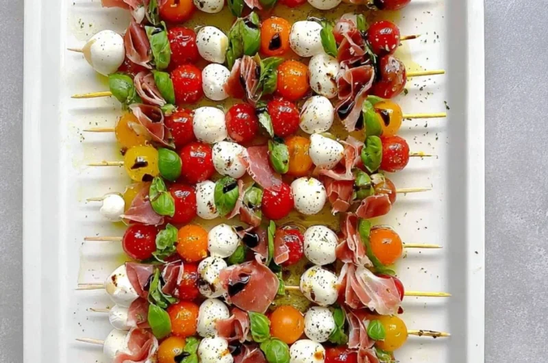 Mini Caprese Salad Skewers with mozzarella, tomatoes, and basil on a platter