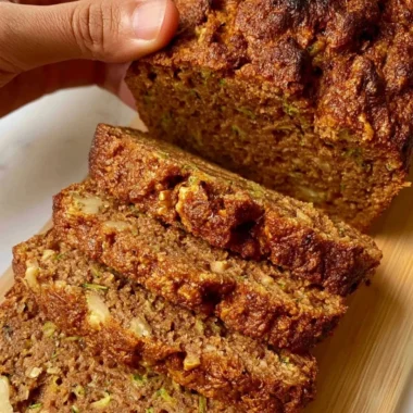 Delicious slice of homemade best zucchini bread on a wooden cutting board