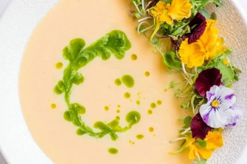 Chilled peach soup garnished with mint leaves in a bowl