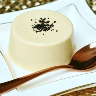 Earl Grey Panna Cotta dessert on a plate with tea leaves and flowers