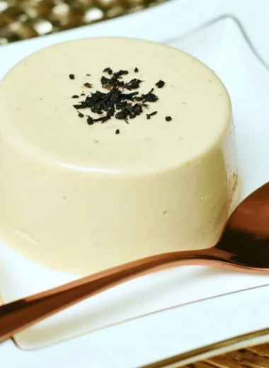 Earl Grey Panna Cotta dessert on a plate with tea leaves and flowers