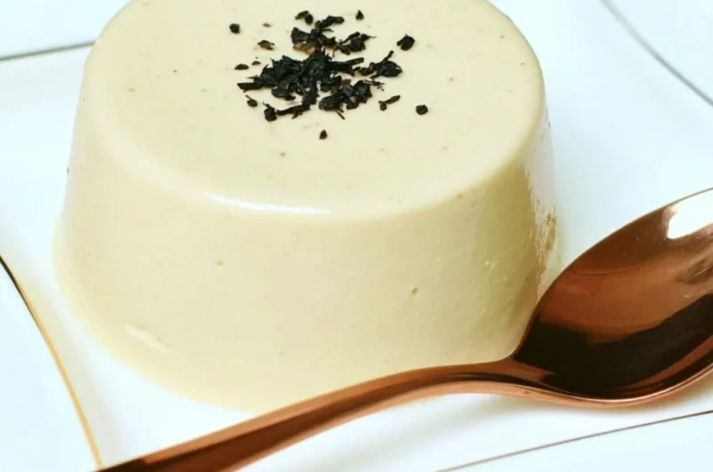 Earl Grey Panna Cotta dessert on a plate with tea leaves and flowers