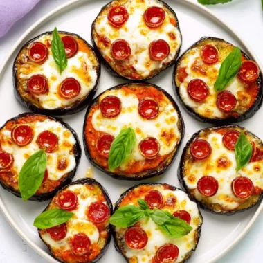 Easy mini eggplant pizza topped with cheese and tomatoes on a baking sheet