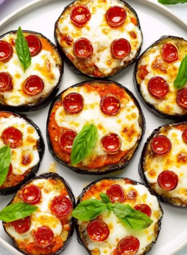 Easy mini eggplant pizza topped with cheese and tomatoes on a baking sheet