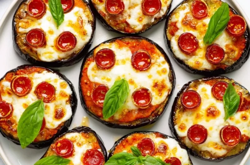 Easy mini eggplant pizza topped with cheese and tomatoes on a baking sheet