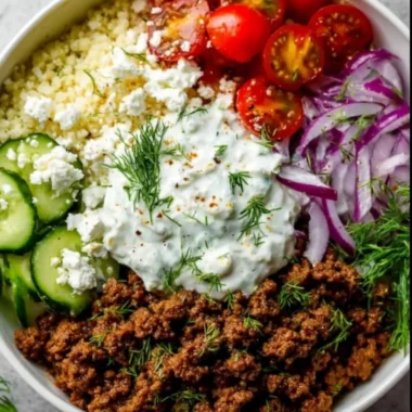 Greek Ground Beef Bowl topped with creamy Tzatziki sauce and fresh vegetables