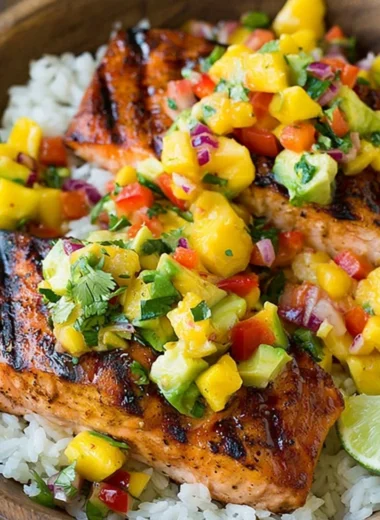 Delicious grilled salmon with fresh mango salsa and coconut rice on a plate