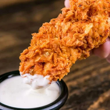 Plate of crispy homemade buttermilk chicken tenders served with dipping sauce.