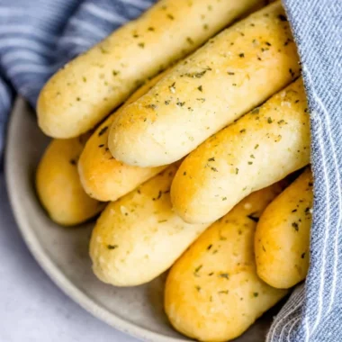 Homemade garlic herb breadsticks fresh out of the oven with a golden crust.