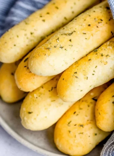 Homemade garlic herb breadsticks fresh out of the oven with a golden crust.