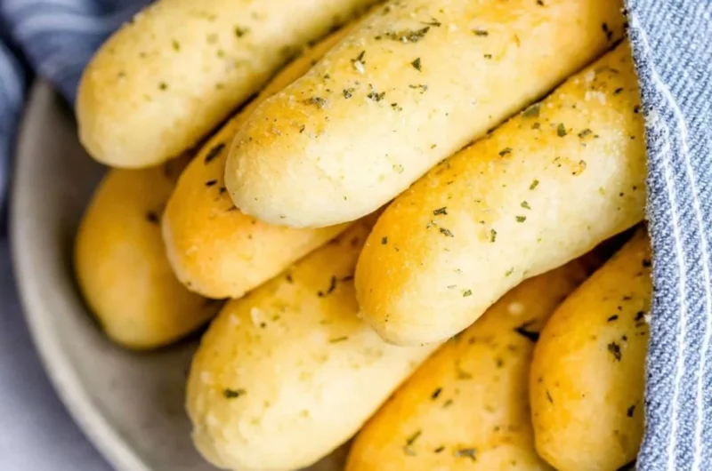 Homemade garlic herb breadsticks fresh out of the oven with a golden crust.