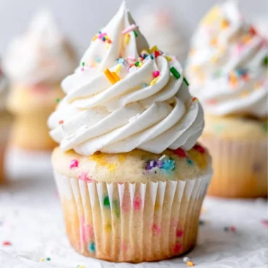 Delicious homemade vanilla cupcakes decorated with frosting and sprinkles