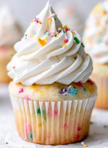 Delicious homemade vanilla cupcakes decorated with frosting and sprinkles