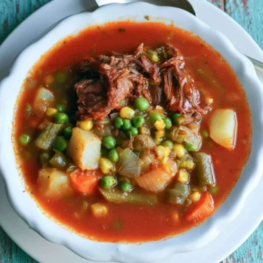 Bowl of my mom's old-fashioned vegetable beef soup with colorful veggies and beef chunks