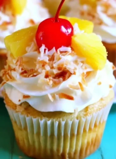 Pina Colada Cupcakes topped with coconut and pineapple frosting