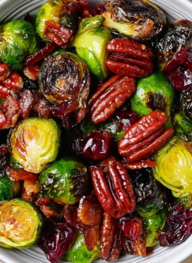 Roasted Brussels sprouts with bacon, toasted pecans, and dried cranberries in a bowl.