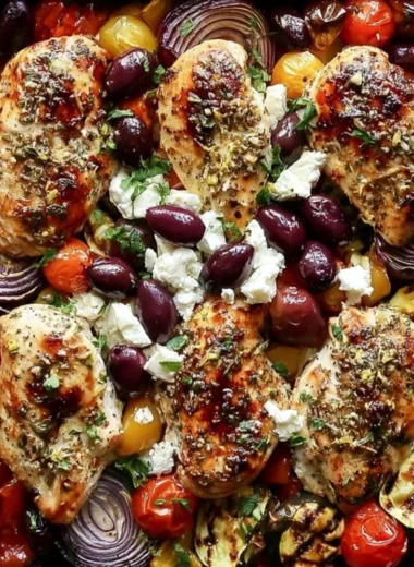 Sheet Pan Greek Chicken with colorful veggies arranged on a baking tray