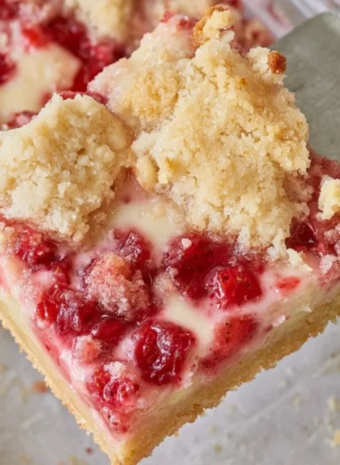 Delicious strawberry pie bars on a wooden table with fresh strawberries