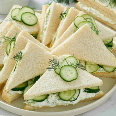 Delicious cucumber sandwiches served alongside tuna and fresh tomatoes