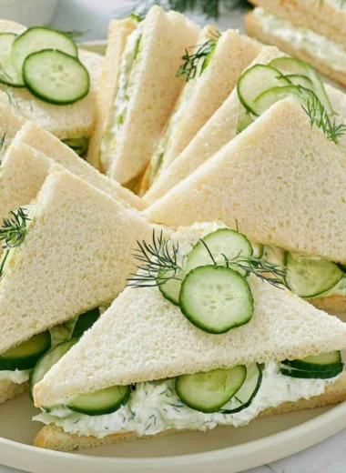 Delicious cucumber sandwiches served alongside tuna and fresh tomatoes