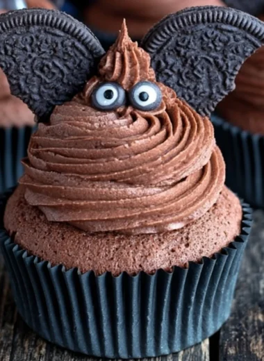 Cute bat cupcake decorated with chocolate frosting and candy eyes for Halloween.
