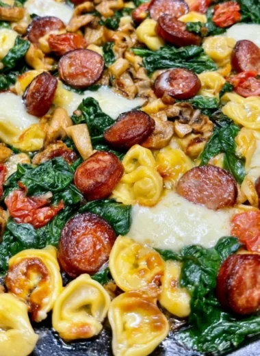 Plate of Blackstone Sausage with tortellini and spinach garnished