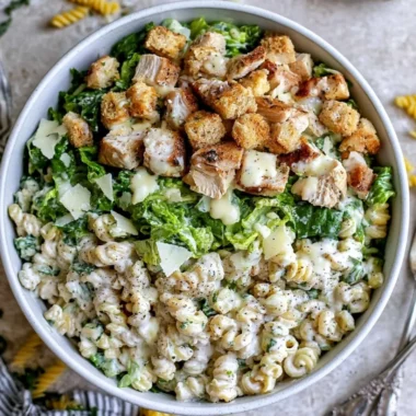 Delicious Chicken Caesar Pasta Salad garnished with croutons and parmesan cheese.