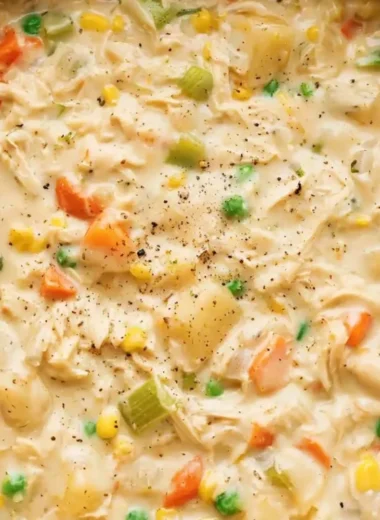 A bowl of creamy Chicken Pot Pie Soup garnished with herbs.