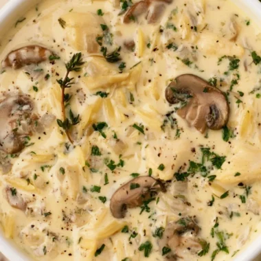 Creamy chicken soup with Boursin cheese in a bowl garnished with herbs