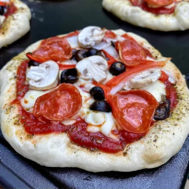 Homemade delicious pizza cooking on a Blackstone griddle.