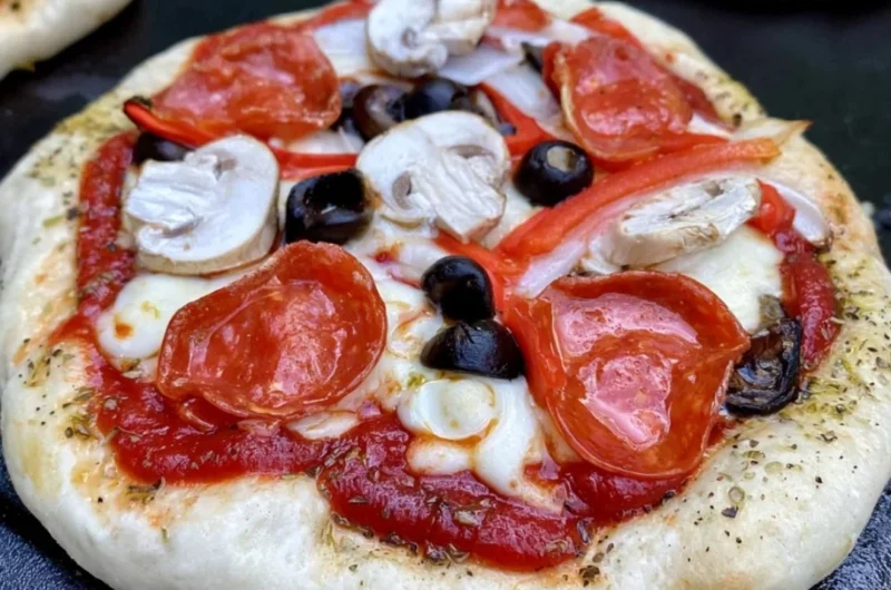 Homemade delicious pizza cooking on a Blackstone griddle.