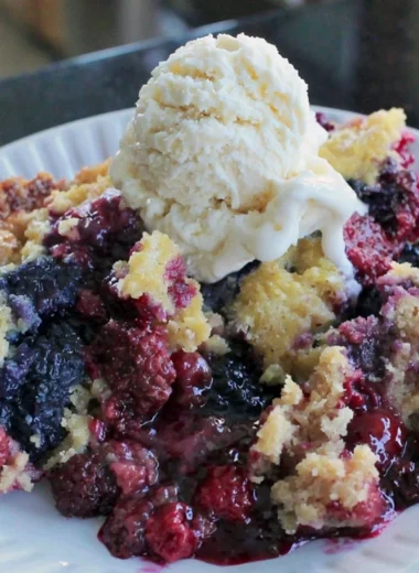 Fresh blackberry dump cake topped with whipped cream and berries