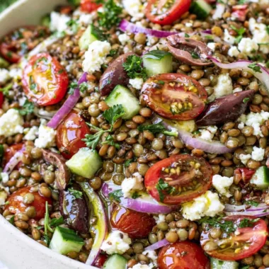 Bowl of vibrant lentil salad with fresh vegetables and a drizzle of dressing