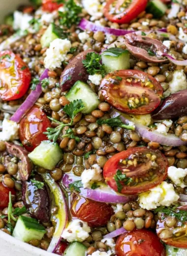 Bowl of vibrant lentil salad with fresh vegetables and a drizzle of dressing