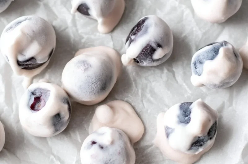 Bowl of yogurt covered blueberries, a healthy and sweet snack option.