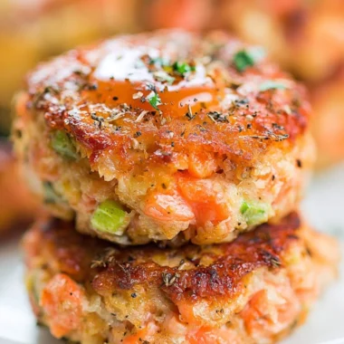 Crispy salmon cakes served with honey sriracha sauce on a plate.