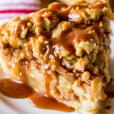 Delicious Dutch Caramel Apple Pie with caramel drizzled on top and fresh apple slices