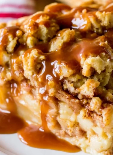 Delicious Dutch Caramel Apple Pie with caramel drizzled on top and fresh apple slices