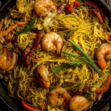 A plate of colorful Singapore Noodles with shrimp and vegetables