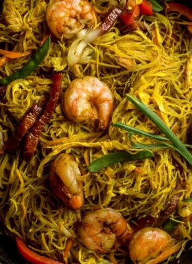 A plate of colorful Singapore Noodles with shrimp and vegetables